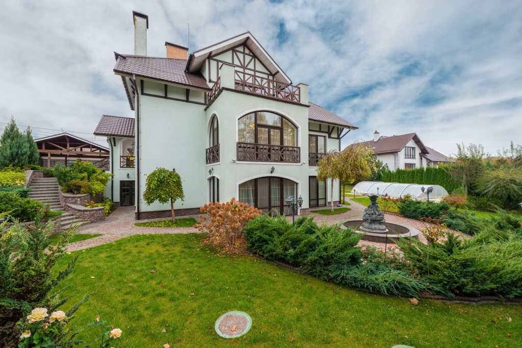 Elegant villa surrounded by a vibrant garden, showcasing residential architecture and landscape design.